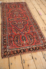 Angled view of a finely woven vintage Sarouk runner with brick red floral bouquets.