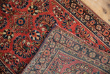 Folded corner of a vintage Sarouk rug revealing its hand-knotted back and weave.