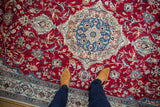 Intricate medallion and scrolling vinery with birds on a cherry red Persian carpet.