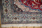 Finely woven corner of a Nain rug with a dragon spandrel, scrolling floral borders, and white fringe.