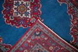Reverse view of a fine Kashan rug's corner, showing the hand-knotted weave of the floral border.