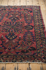 Persian Lilihan rug with cherry red field, navy quatrefoil blossoms, scrolling leaves, and vine border.