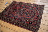 Vintage Lilihan rug corner with cherry red field, double quatrefoil blossoms, navy, and gold details.