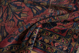 Lilihan rug detail with cherry red field, navy vine border, and machine-bound side.