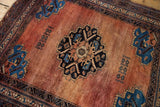 Antique Afshar rug corner: sapphire blue germinating plant spandrel on an abrashed red field.