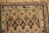 Tattered fringe and detailed geometric guls in camel, pink, brown on the vintage Caucasian rug.