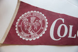 Vintage maroon felt Colgate University pennant with white seal and 'Col' lettering.