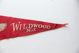 Vintage red felt Wildwood N.J. pennant, showing pointed tip and textured surface.