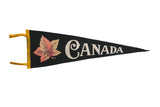 Vintage black felt Canada pennant with a soft reddish-orange maple leaf and white text, 9x26 inches.