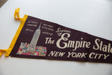 Deep brown vintage felt pennant showing 'Souvenir of The Empire State New York City' text.