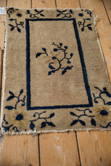 Antique Chinese Peking rug corner with cobalt blue border, rose floral, and worn edge.