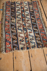 Close-up on the tattered edge and striped water motif of an antique Anatolian rug mat.