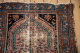 Vintage Mehreban rug corner showing stepped finial motif, muted red field, blue border, wear.