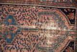 Vintage Mehreban rug detail with pronounced foundation wear and dusty red, blue patterns.