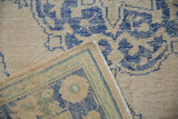 Distressed Oushak rug: worn beige pile, blue pattern, and tight hand-knotted reverse.