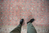 Distressed vintage Sparta carpet's faded blush, blue, and ivory floral vinery.