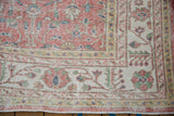 Vintage Distressed Sparta carpet corner with worn blush field and geometric ivory border.