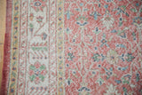 Worn vintage Sparta carpet texture with faded blush field and scrolling floral vinery.