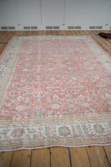 Worn field of vintage Sparta carpet with blush, ivory, and blue scrolling floral vinery.