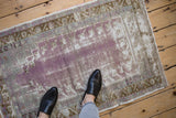 Distressed Vintage Oushak rug showing worn pile, faded violet, aubergine, and bronze.