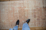 A standing view showing the soft, worn texture of a distressed vintage Oushak rug runner.