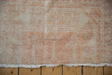 Evenly worn pile showing the knot heads and short fringe of the Oushak rug.