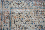 Distressed Oushak rug corner detail with beige palmettes, sky blue vinery, and Samovar border.
