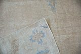 Distressed Oushak carpet pile with mostly even wear, visible foundation, and restored side selvage.
