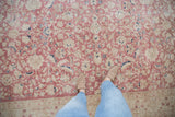 Distressed vintage Sparta carpet with faded pink, ivory, and navy palmette patterns.