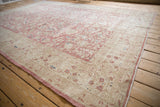 Distressed beige border with faded pink floral motifs and blue accents.