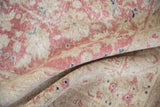 Distressed texture of a vintage Sparta carpet, revealing faded pink and ivory floral motifs with navy accents.