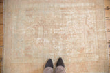 Distressed Oushak square rug, faded ivory and rose floral motifs with visible foundation wear.