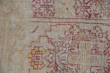 Distressed Oushak rug pile: ivory, beige, and red stepped pattern, with worn knot heads.