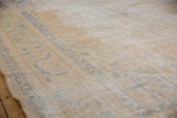 Distressed vintage Oushak carpet's worn beige pile showing foundation and faint blue pattern.