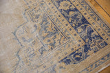 Distressed texture of vintage Oushak, with worn cream field and cobalt blue border abrash.