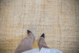 Low pile texture of a distressed vintage Oushak carpet showing visible wear and knot heads.