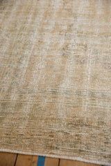Angled close-up of the distressed, hand-knotted pile showing wear to the knot heads.