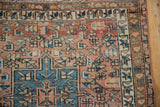 Close-up of intricate geometric motifs and distressed pile on a vintage Karaja rug.