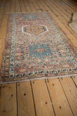 Distressed vintage Karaja rug with geometric field motifs in muted rose, blue, and orange tones.