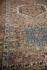 Textured vintage Karaja rug's geometric border, dusty rose field with floral buds and pinwheels.