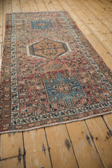 Distressed Karaja rug corner showing geometric patterns, fringe, and faint foundation.