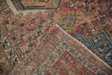 Vintage distressed Karaja rug corner, revealing geometric dusty rose pile and woven backing.