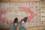 Textured pile on a distressed vintage Oushak rug with dusty raspberry and ivory.