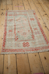Distressed pile of vintage Oushak rug, showing worn tangerine orange motifs.