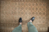 Distressed Afghani Bokhara design rug showing pale copper elephant footprint gul and even wear.