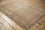 Vintage distressed Afghani Bokhara rug corner showing geometric border and stylized gul pattern.