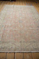 Low pile texture with dusty rose and ivory floral motifs on a vintage Sparta rug.