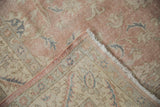 Corner of distressed vintage Sparta carpet showing hand-knotted foundation and worn rose pile.