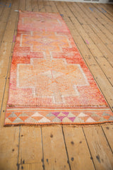 Distressed Kurd runner end, featuring geometric tribal border in dusty raspberry and tangerine tones.