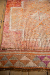 Distressed Kurd rug pile with subtle abrashed orange and geometric violet patterned border.